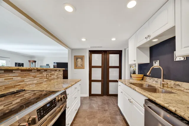 a kitchen with stainless steel appliances granite countertop a sink and stove