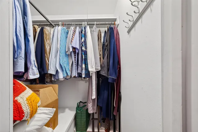 a view of walk in closet with clothes
