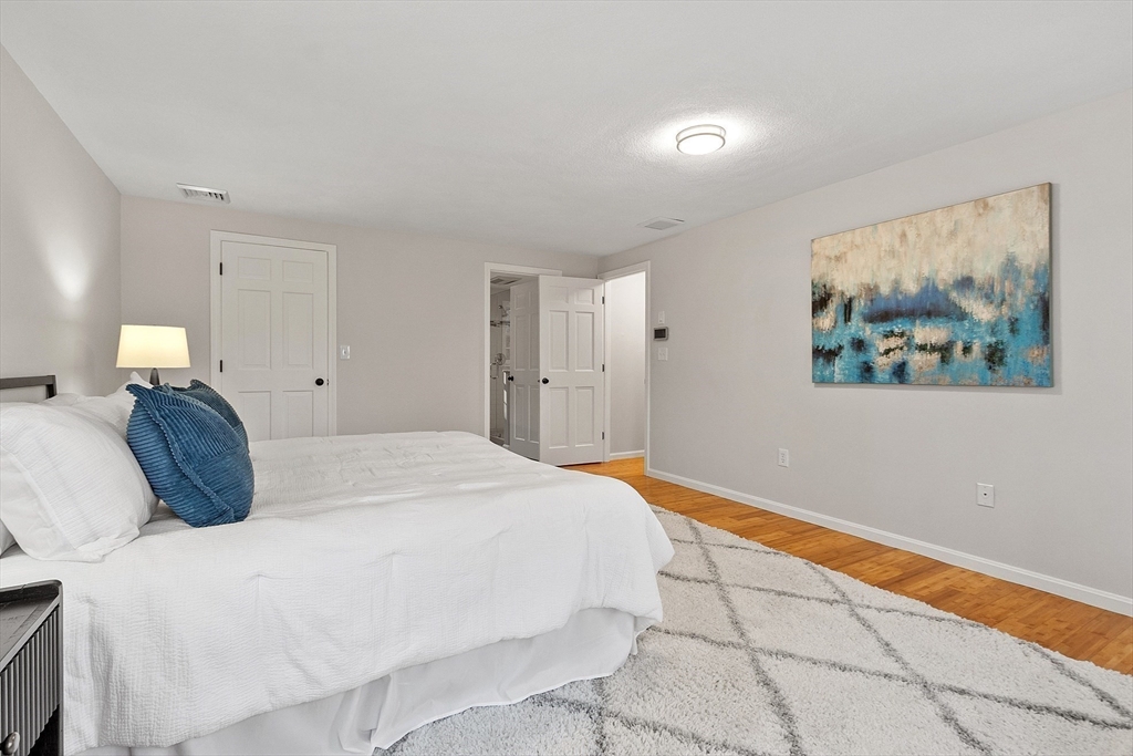 14 October Lane Stow, MA 01775 - Photo 22 of 41 a bedroom with a bed and a painting on the wall