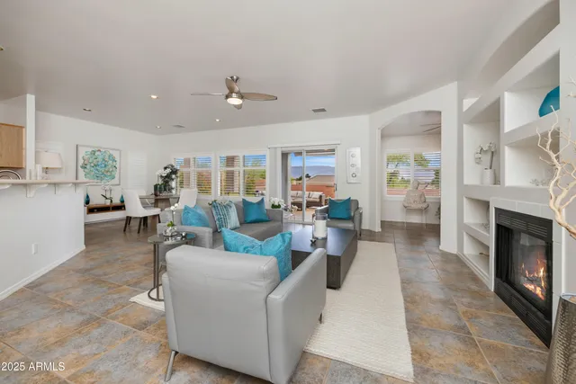 a living room with furniture a fireplace and a view of kitchen