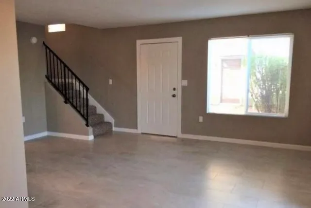 a view of an empty room with wooden floor and windows
