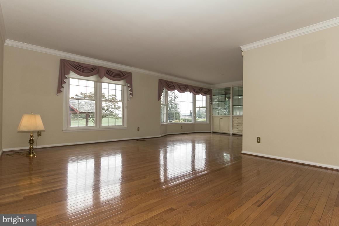 9911 Pepper Hill Road Perry Hall, MD 21128 - Photo 3 of 30 a view of an empty room with wooden floor and a window