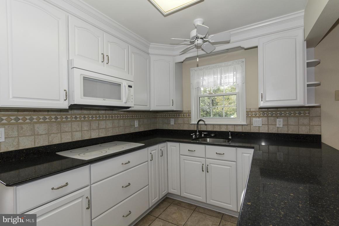 9911 Pepper Hill Road Perry Hall, MD 21128 - Photo 6 of 30 a kitchen with granite countertop white cabinets white appliances and a sink