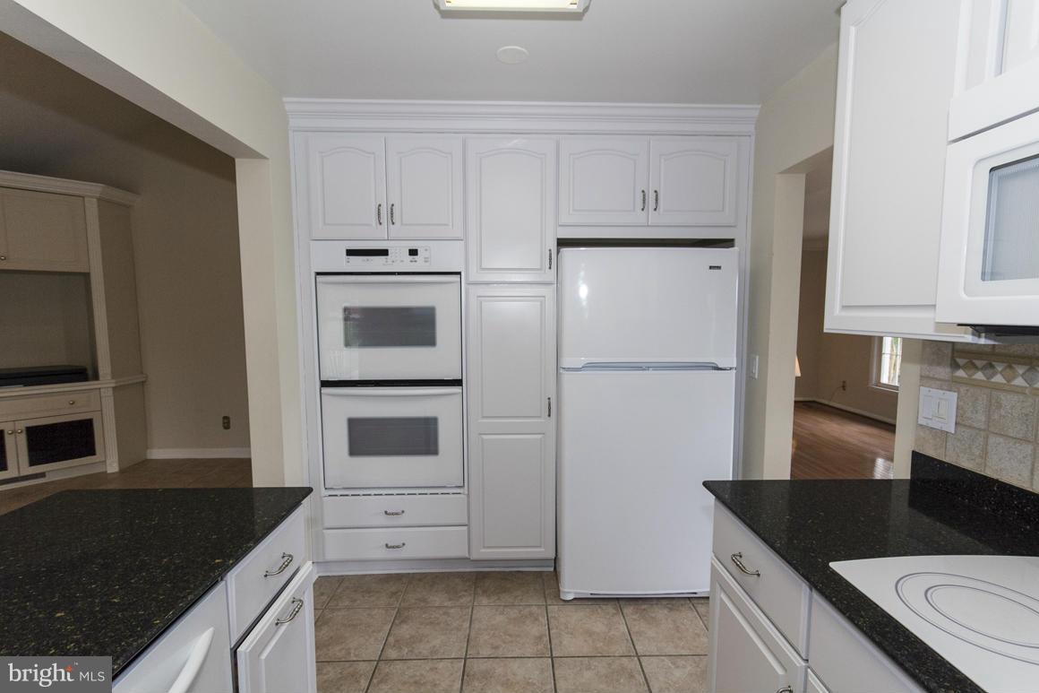 9911 Pepper Hill Road Perry Hall, MD 21128 - Photo 8 of 30 a kitchen with granite countertop white cabinets and refrigerator