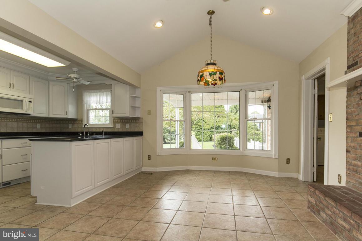 9911 Pepper Hill Road Perry Hall, MD 21128 - Photo 10 of 30 a large kitchen with kitchen island granite countertop a stove a sink a window and a counter space