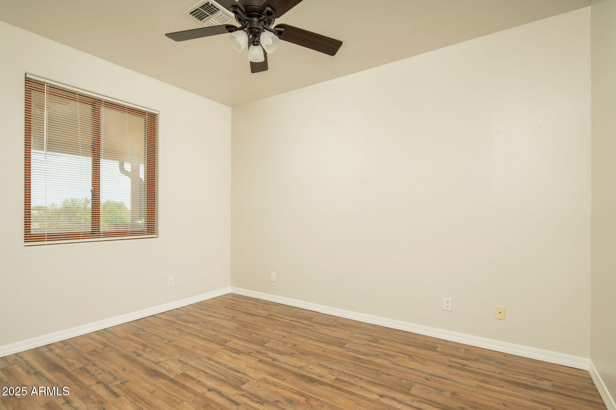 29362 North Varnum Road San Tan Valley, AZ 85143 - Photo 7 of 27 a view of an empty room with wooden floor and a window