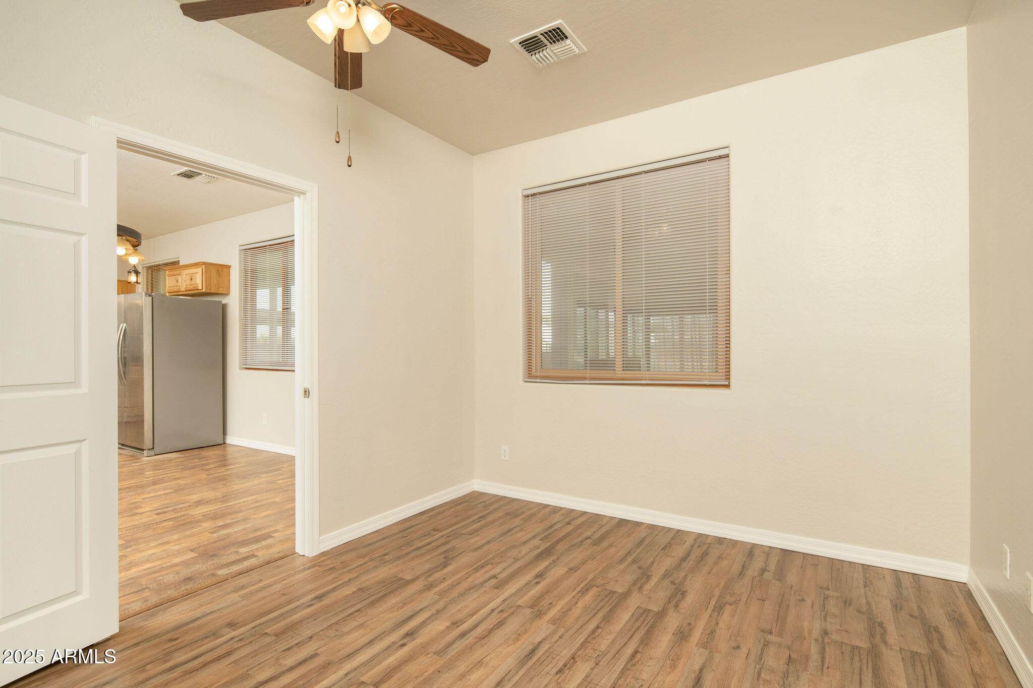 29362 North Varnum Road San Tan Valley, AZ 85143 - Photo 10 of 27 a view of an empty room with wooden floor and a chandelier fan
