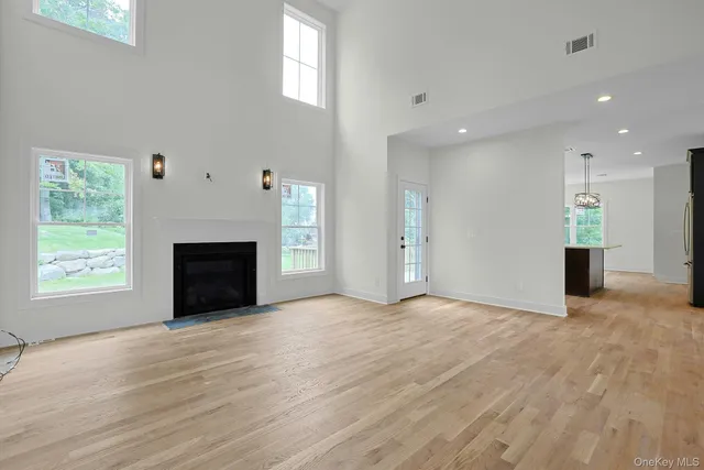 an empty room with windows and fireplace