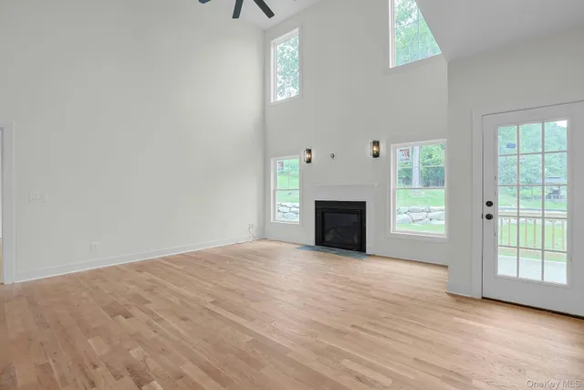 a view of an empty room with a fireplace and a window