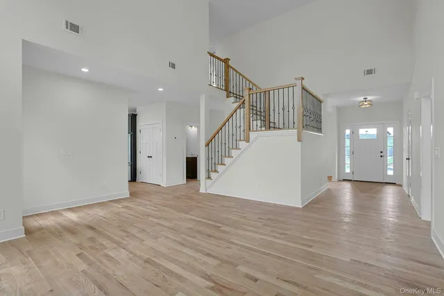 a view of a hallway with wooden floor and stairs