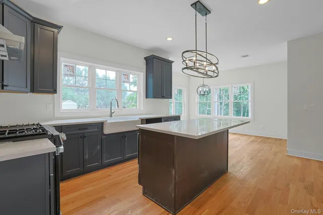 a kitchen with granite countertop a stove a sink dishwasher and a dining table with wooden floor