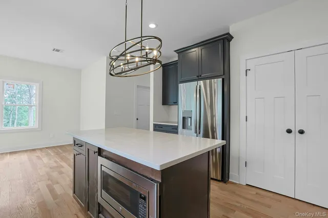 a kitchen with stainless steel appliances a microwave a stove and a refrigerator