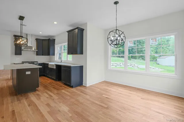 a kitchen with stainless steel appliances granite countertop a stove a sink dishwasher and a refrigerator with wooden floor