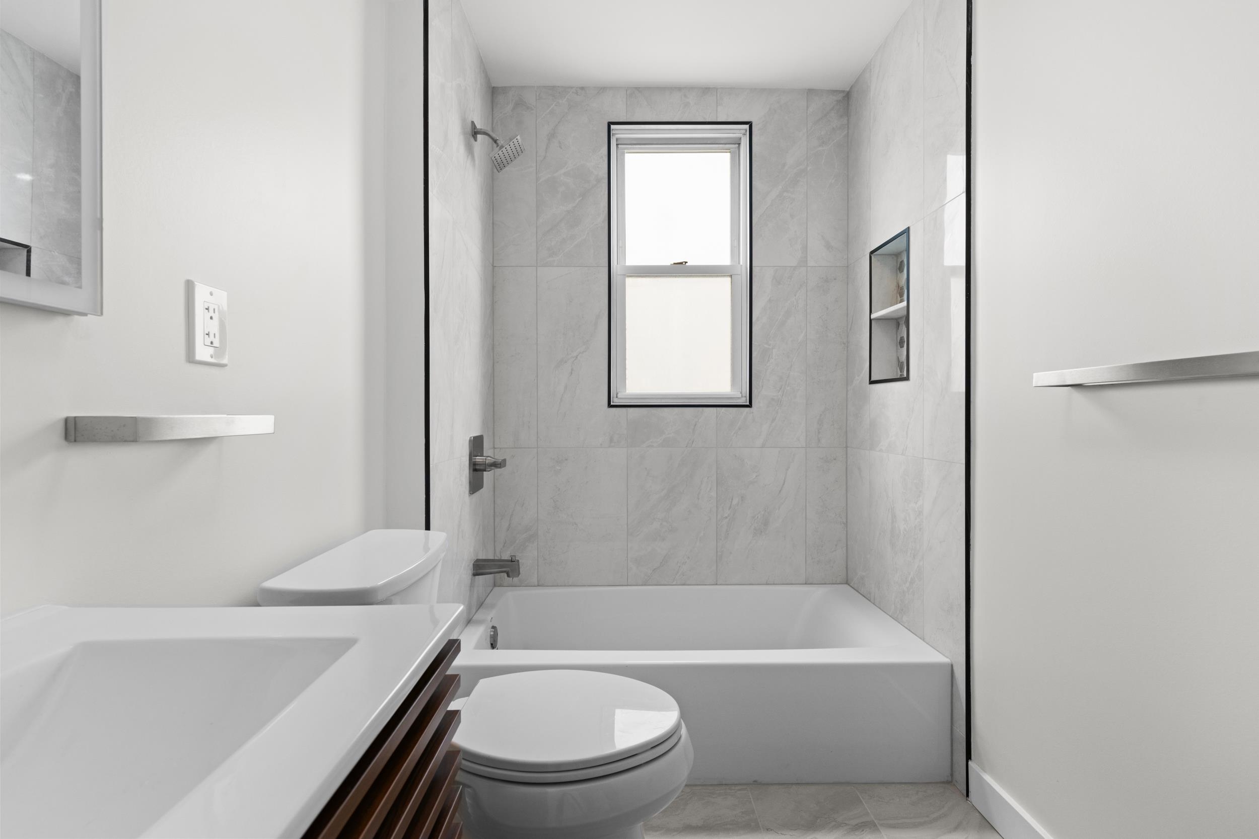 3 Edison Place, Unit 1 East Rutherford, NJ 07073 - Photo 14 of 21 a bathroom with a toilet a sink and bathtub