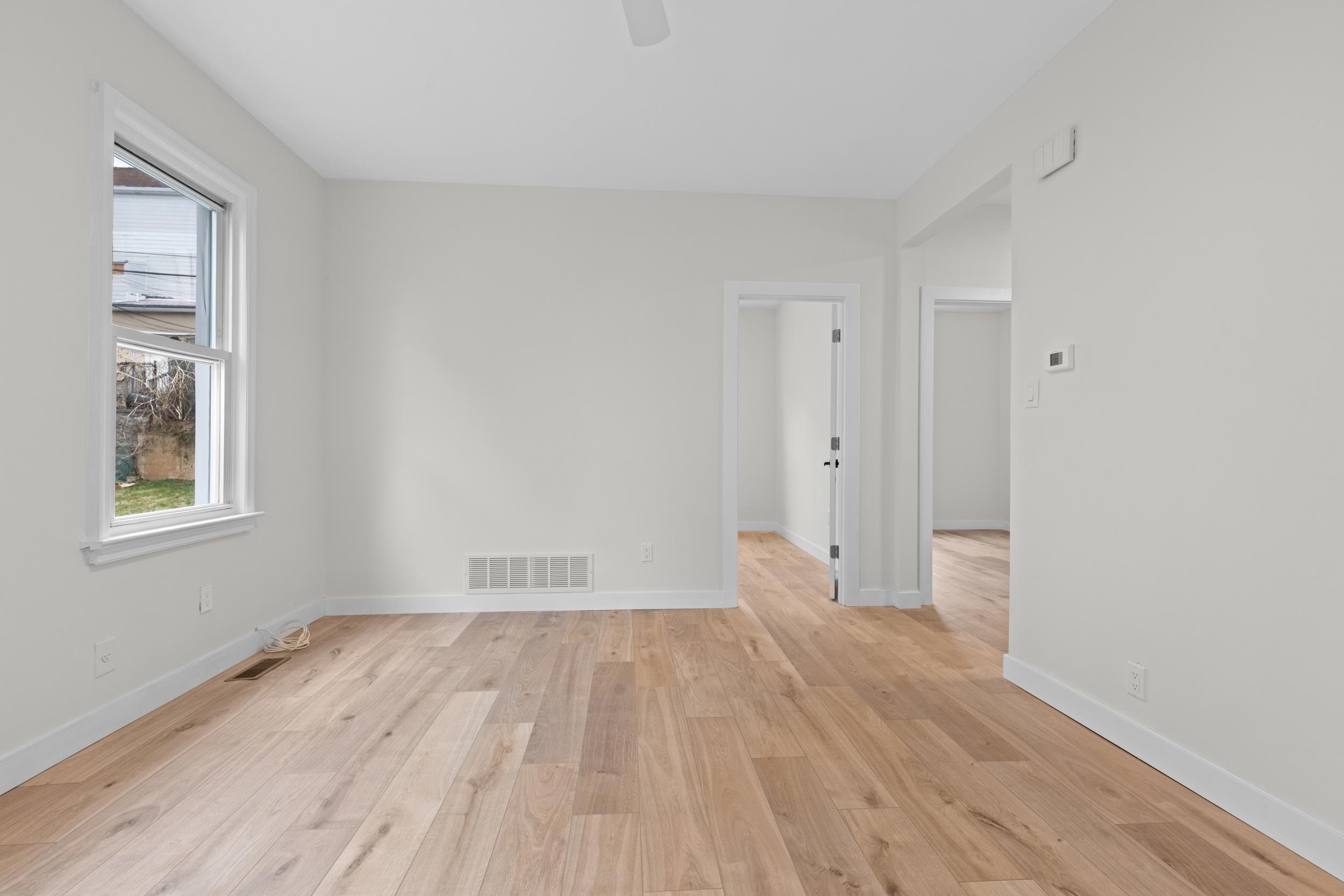3 Edison Place, Unit 1 East Rutherford, NJ 07073 - Photo 6 of 21 wooden floor in an empty room with a window