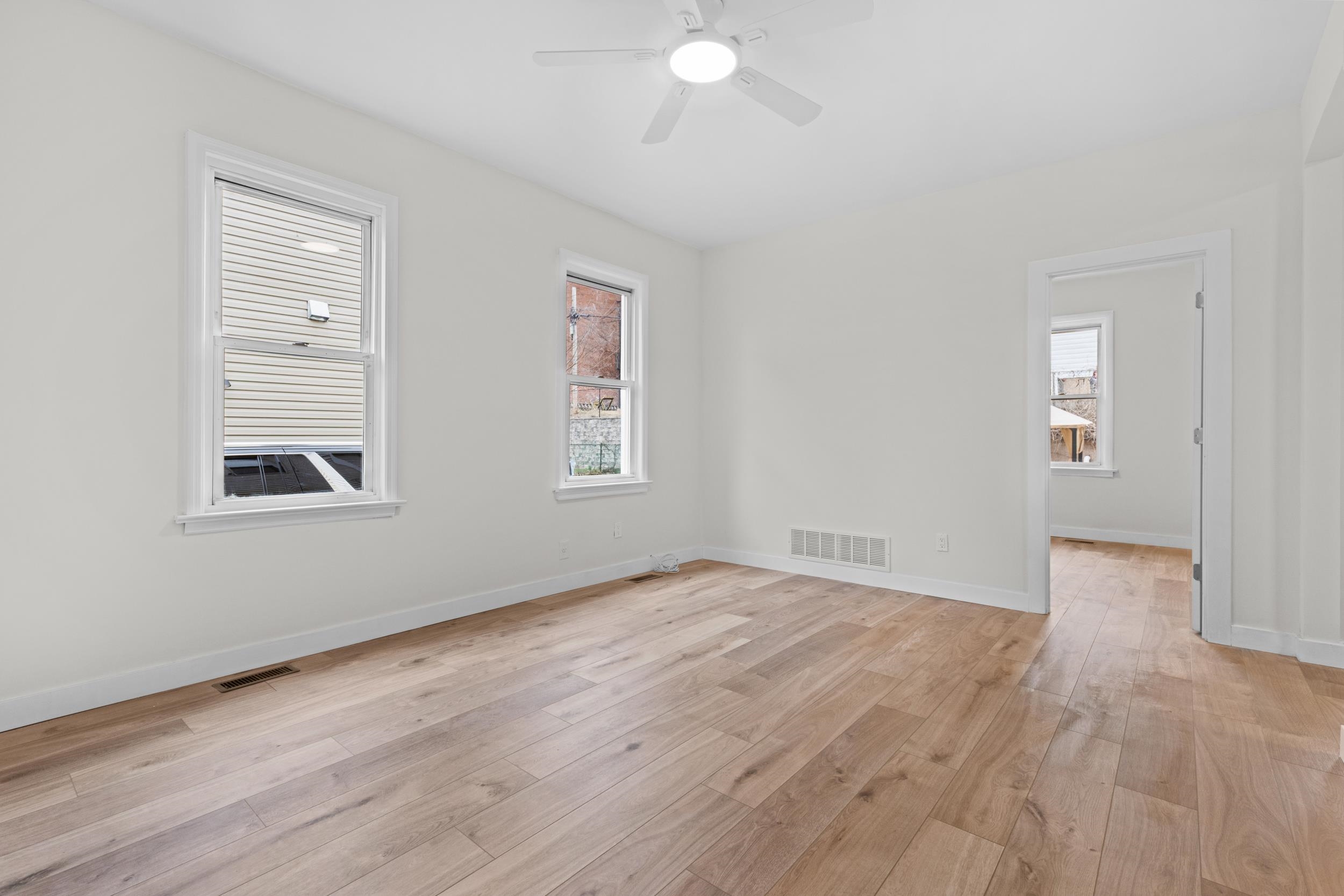 3 Edison Place, Unit 1 East Rutherford, NJ 07073 - Photo 9 of 21 an empty room with wooden floor and windows