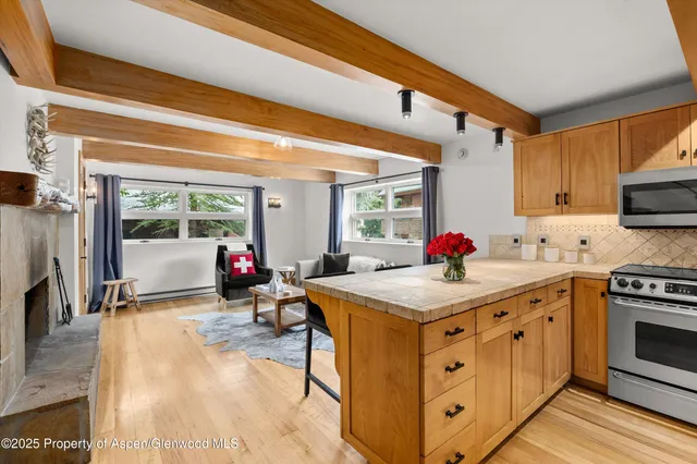 a kitchen with stove a sink dishwasher and a stove with wooden floor