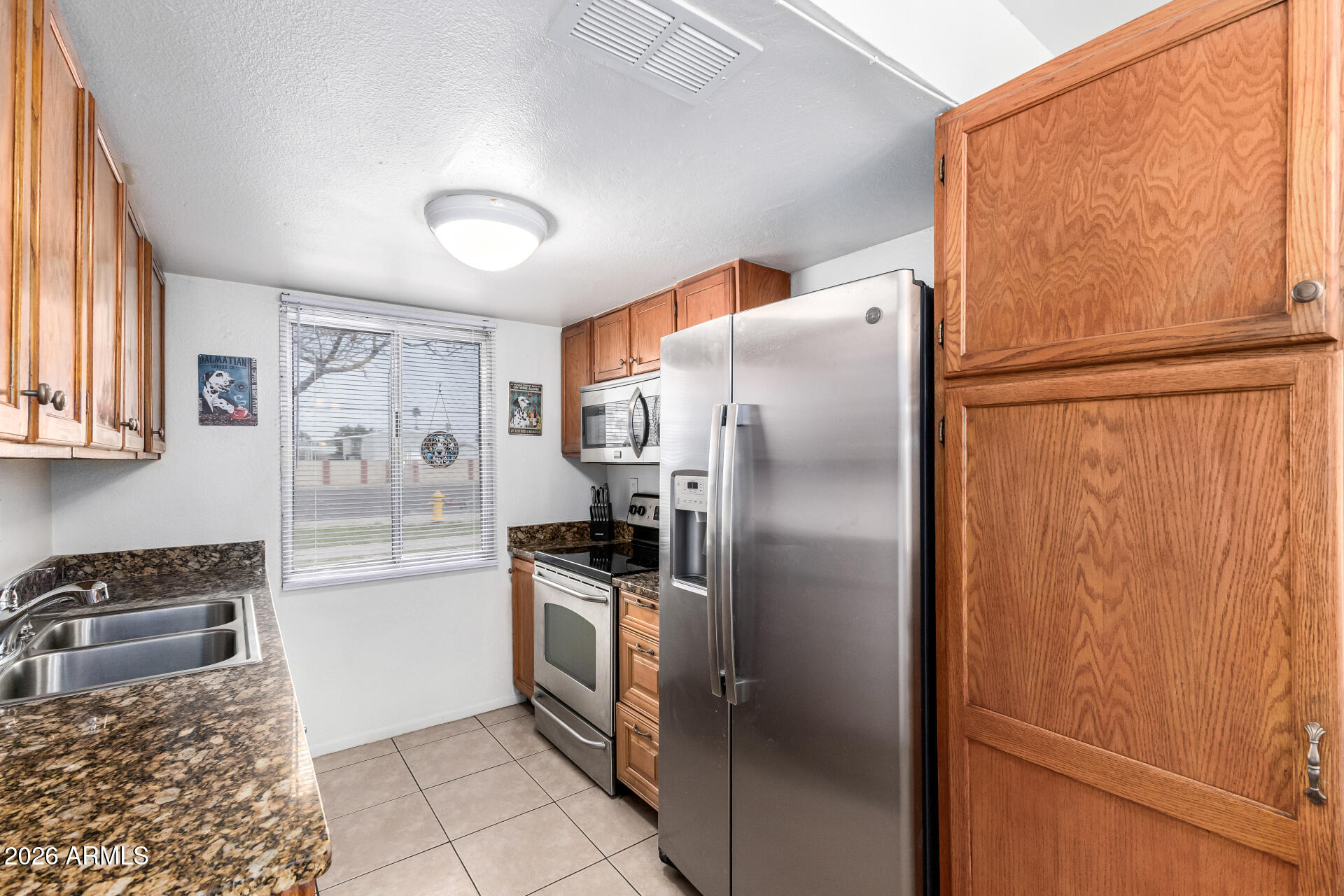 600 South Dobson Road, Unit 122 Mesa, AZ 85202 - Photo 5 of 28 a kitchen with stainless steel appliances granite countertop a refrigerator and a sink