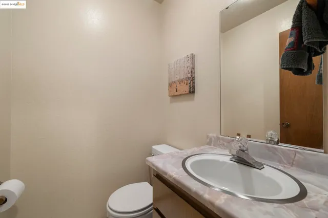 a bathroom with a granite countertop toilet sink and mirror