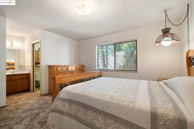 a bedroom with a bed and dresser with mirror