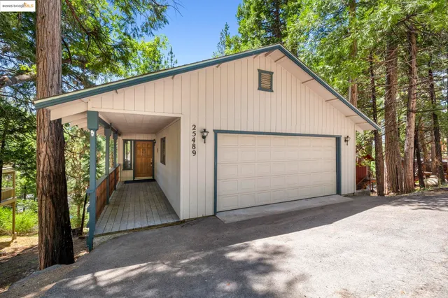 a view of a small house with a garage and balcony