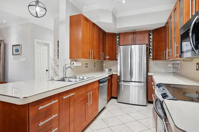 a kitchen with stainless steel appliances granite countertop a stove a sink a microwave and wooden cabinets