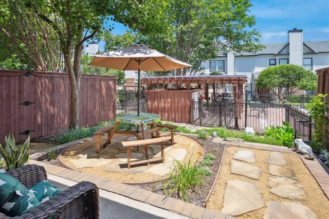 a view of a brick house with a small yard and wooden fence