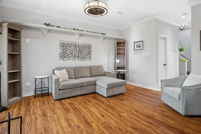 a living room with furniture and a wooden floor