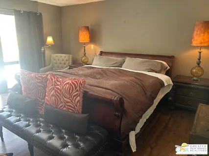 a bedroom with a bed and a lamp on dresser