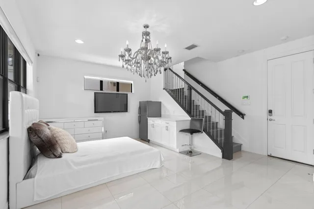 a bedroom with a large bed and a chandelier