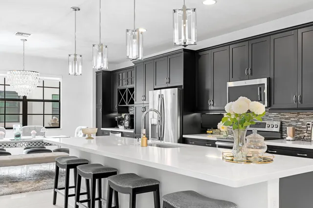 a kitchen with kitchen island granite countertop a sink cabinets and appliances