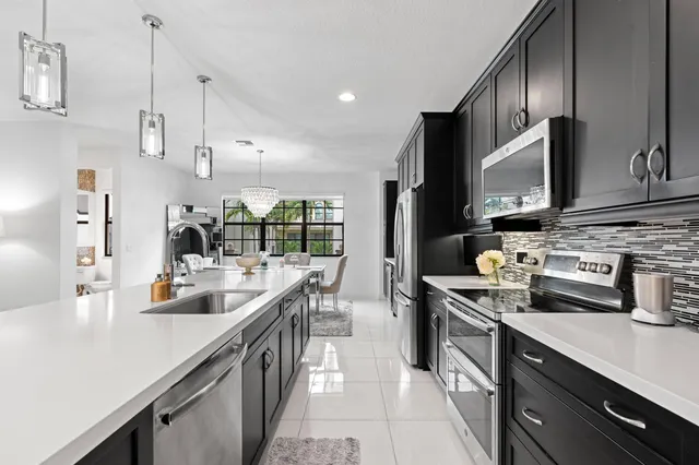 a kitchen with stainless steel appliances a sink a stove and a refrigerator