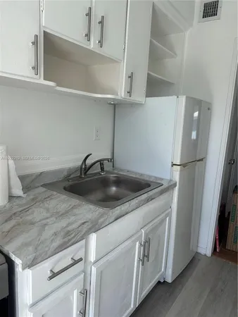a kitchen with stainless steel appliances granite countertop a sink dishwasher a refrigerator and cabinets