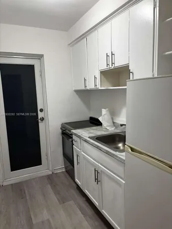 a kitchen with stainless steel appliances granite countertop a stove and a refrigerator with white cabinets