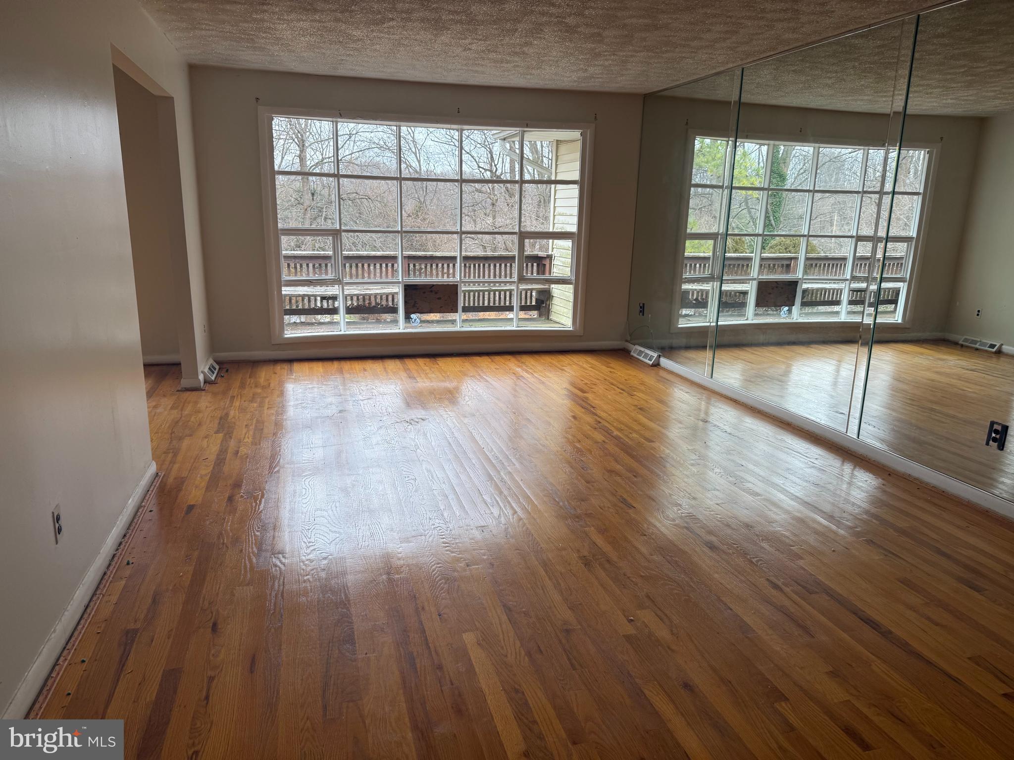 9822 Clanford Road Randallstown, MD 21133 - Photo 2 of 15 wooden floor in an empty room with a window