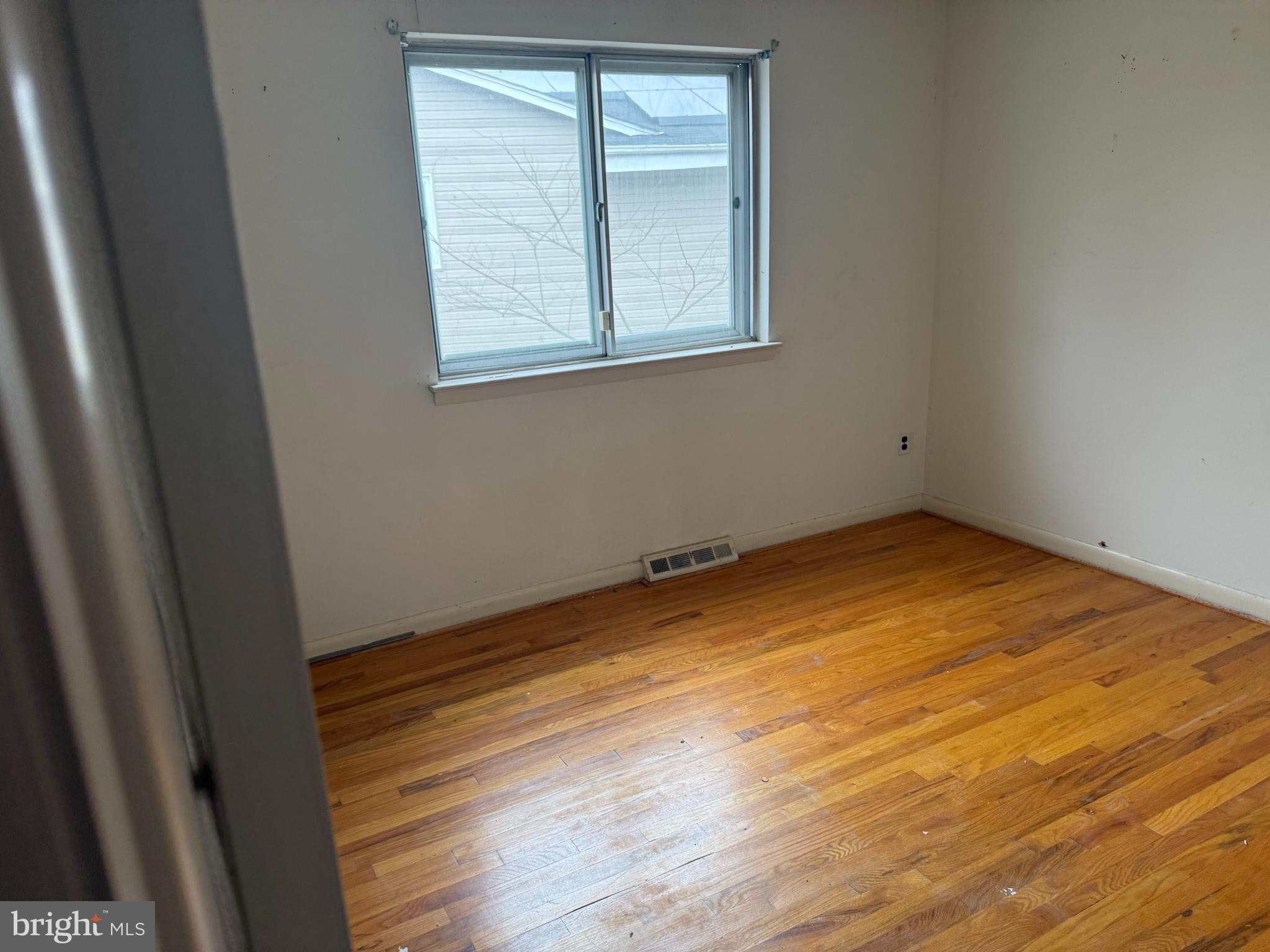 9822 Clanford Road Randallstown, MD 21133 - Photo 10 of 15 an empty room with wooden floor and windows