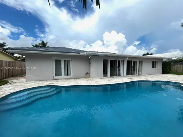 a view of a white house with a tree and yard
