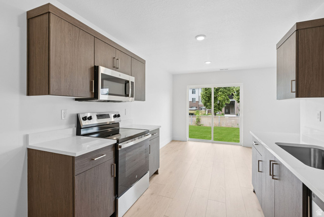 1617 North Angel Street Layton, UT 84041 - Photo 18 of 43 Kitchen with stainless steel appliances, light stone countertops, light wood-type flooring, and modern cabinets