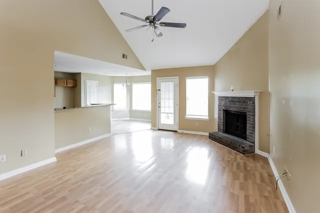 wooden floor fireplace and windows in an empty room