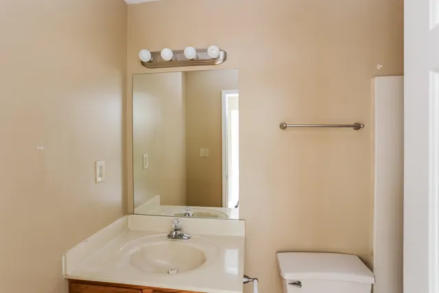 a bathroom with a sink a toilet and mirror