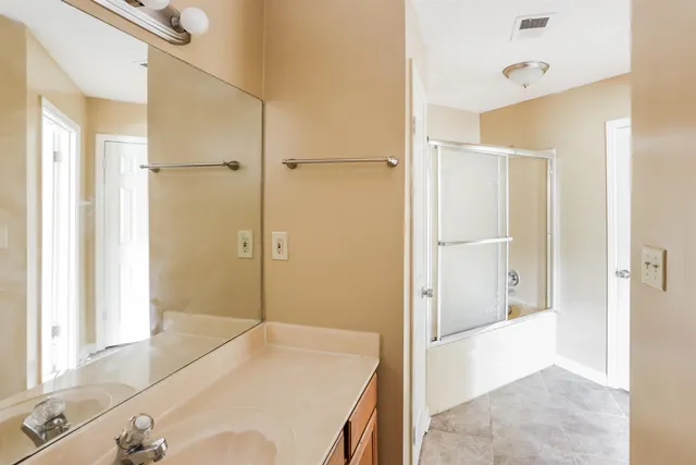 a bathroom with a tub shower and sink