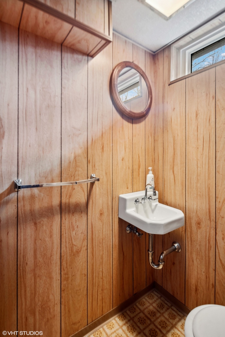 557 Riford Road Glen Ellyn, IL 60137 - Photo 21 of 25 a bathroom with a sink a mirror and a shower