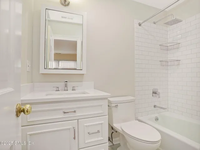 a view of an empty room with wooden floor fireplace and a window