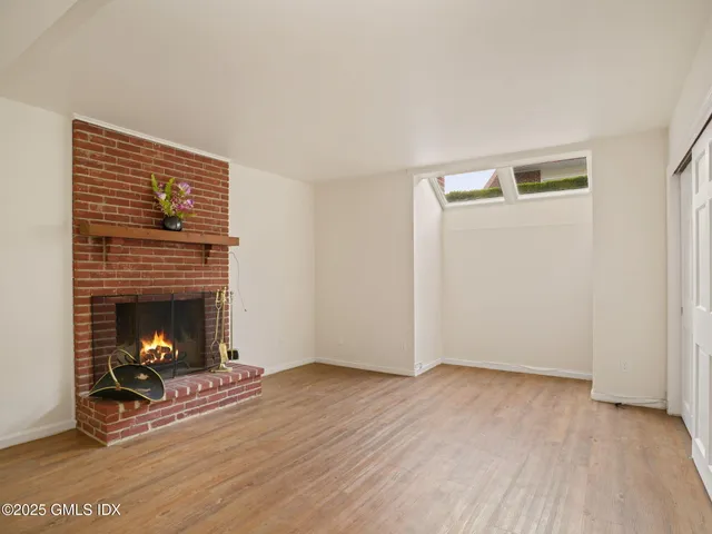 a view of a room with wooden floor and a fireplace