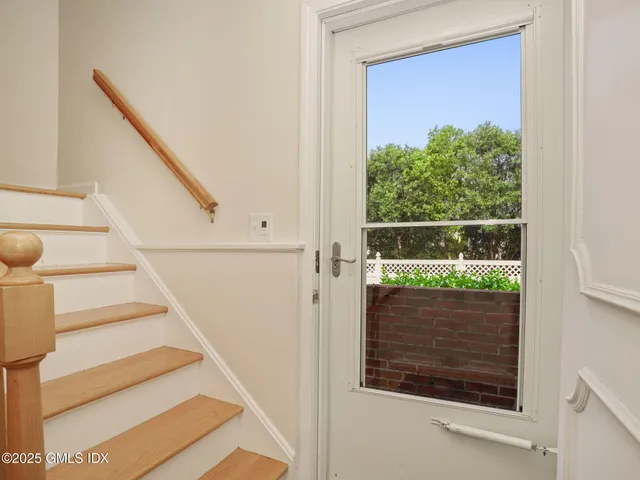 a view of an empty room with wooden floor and a fireplace