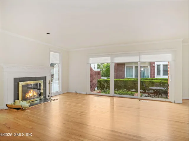 a view of a livingroom with wooden floor a fireplace and windows