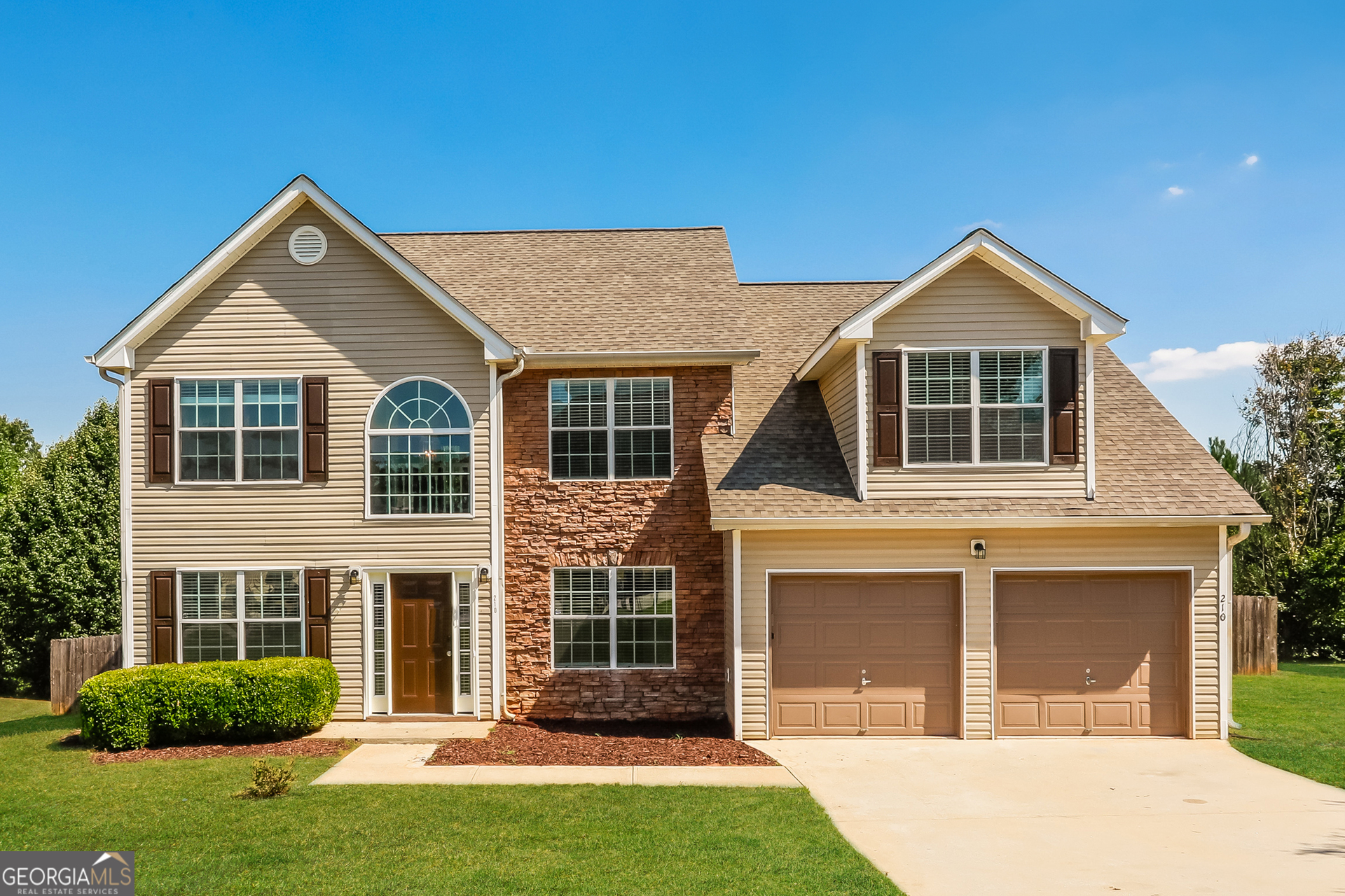 a front view of a house with a yard and garage