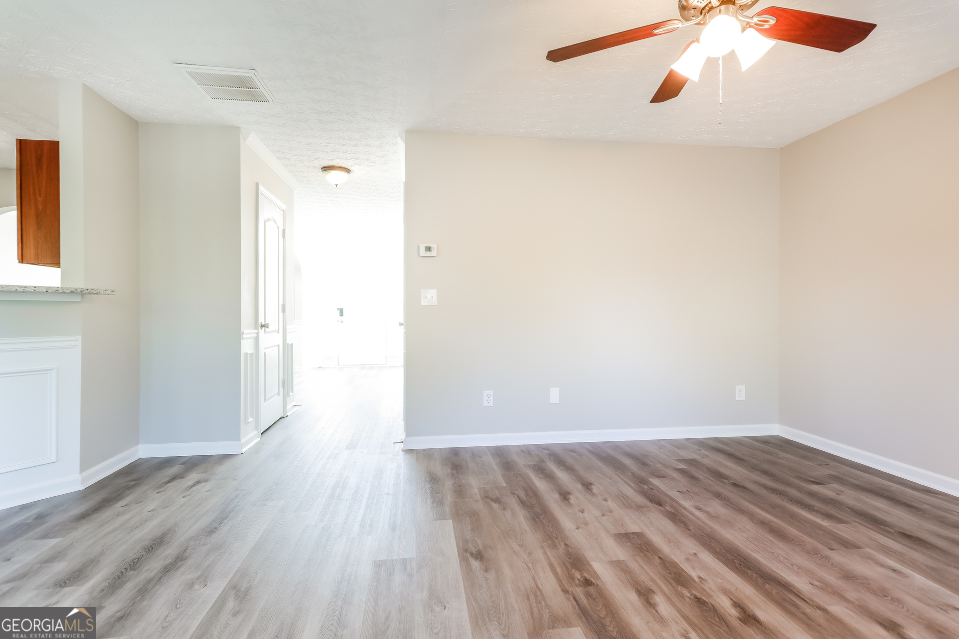210 Heaton Pl Trail Covington, GA 30016 - Photo 3 of 17 an empty room with wooden floor and windows