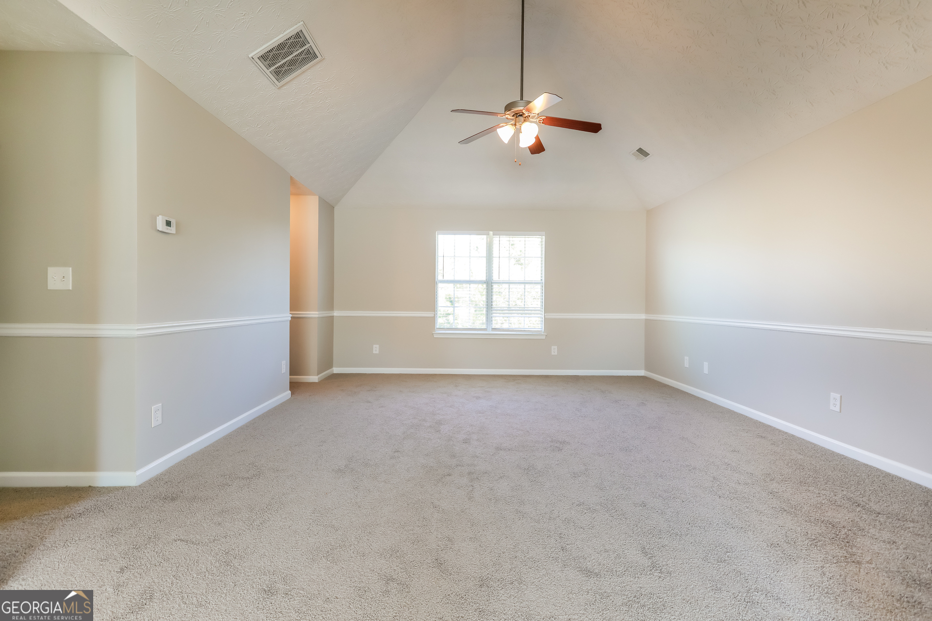210 Heaton Pl Trail Covington, GA 30016 - Photo 7 of 17 an empty room with chandelier fan and windows