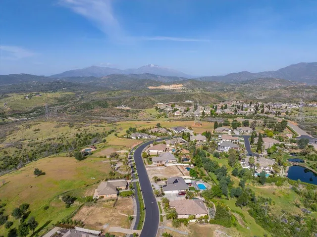 an aerial view of a city with lots of residential buildings and mountain view in back